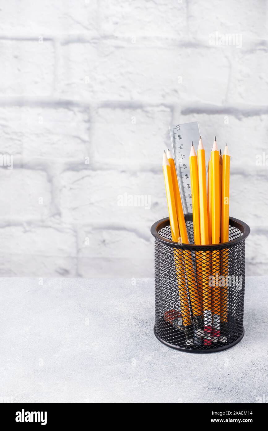 Ensemble de crayons simples lumineux dans un support noir sur une table grise, espace de copie Banque D'Images Ensemble de crayons simples lumineux dans un support noir sur une table grise, espace de copie Banque D'Images