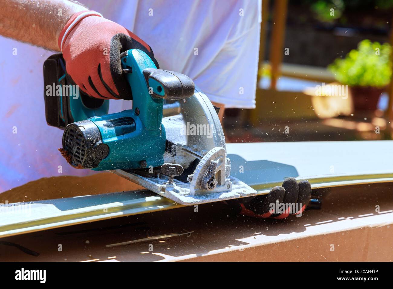 Pendant la façade de construction de l'artisan coupe le panneau de parement de vinyle à la taille désirée avant de l'installer Banque D'Images