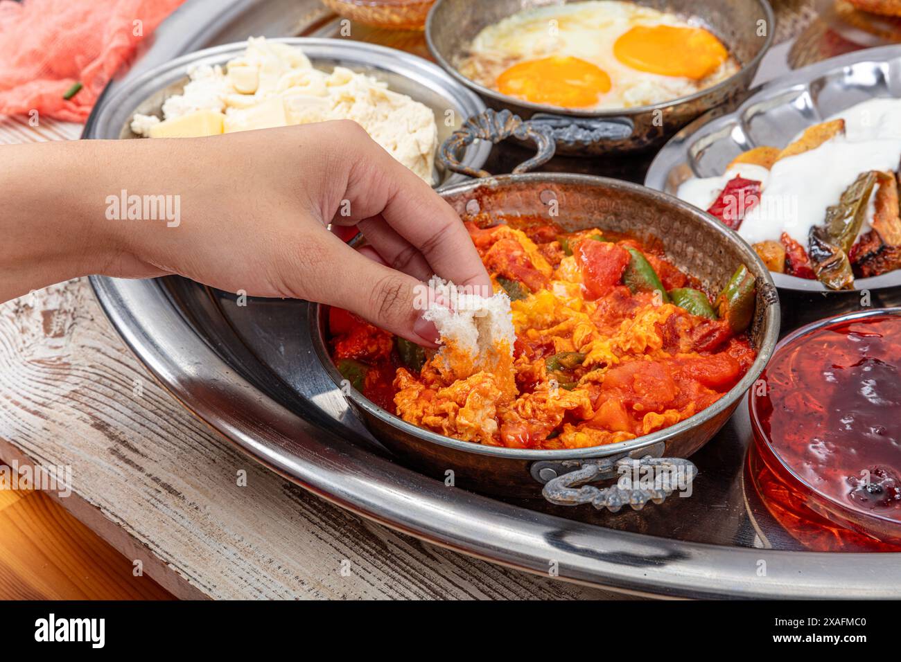 Table de petit déjeuner turc traditionnel (Serpme Kahvalti). Petit déjeuner traditionnel turc du village avec des œufs au plat dans une poêle en cuivre, menemen, miel coagulé c Banque D'Images