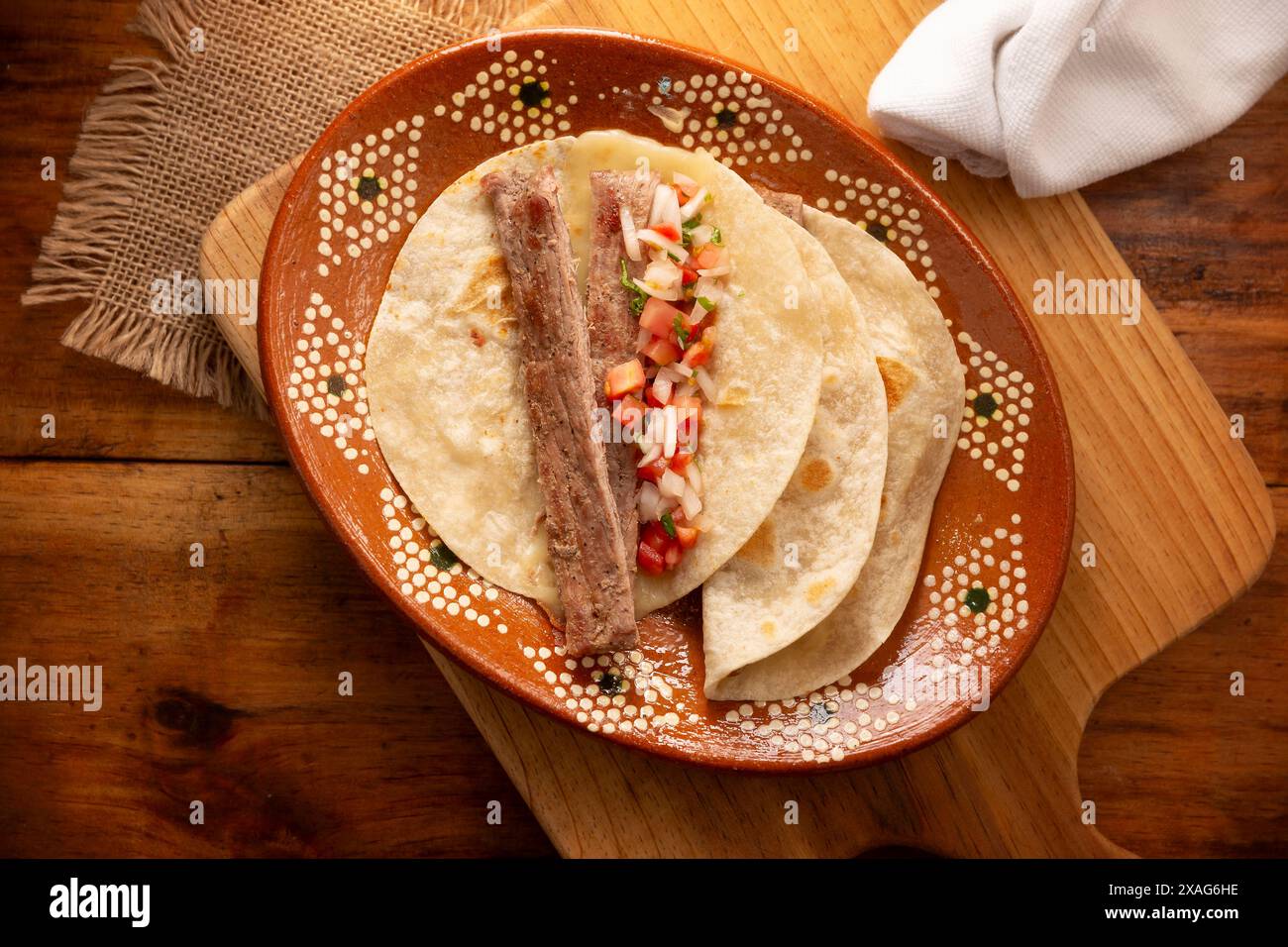 Arrachera Tacos. Steak de bœuf mariné servi dans une tortilla de blé sur une assiette d'argile mexicaine. Cuisine de rue du Mexique, traditionnellement accompagnée de cila Banque D'Images