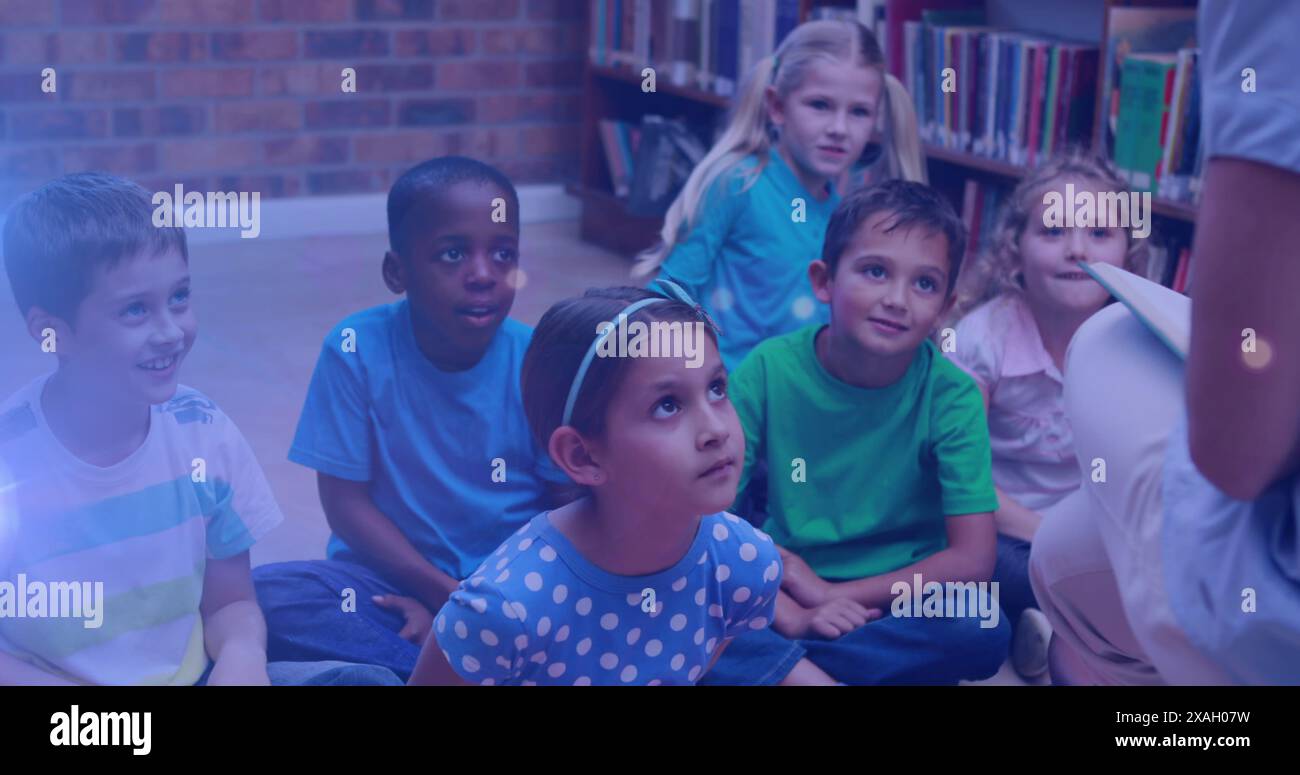 Image de taches lumineuses sur divers écoliers et enseignants lisant des livres dans la bibliothèque Banque D'Images