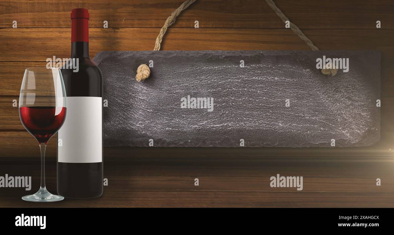 Image de lumières sur une bouteille et un verre de vin rouge sur fond de bois avec étiquette Banque D'Images