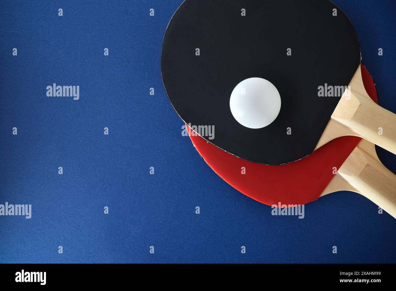Fond avec ensemble de pagaies de tennis de table, et balle blanche isolée sur table bleue. Vue de dessus. Banque D'Images