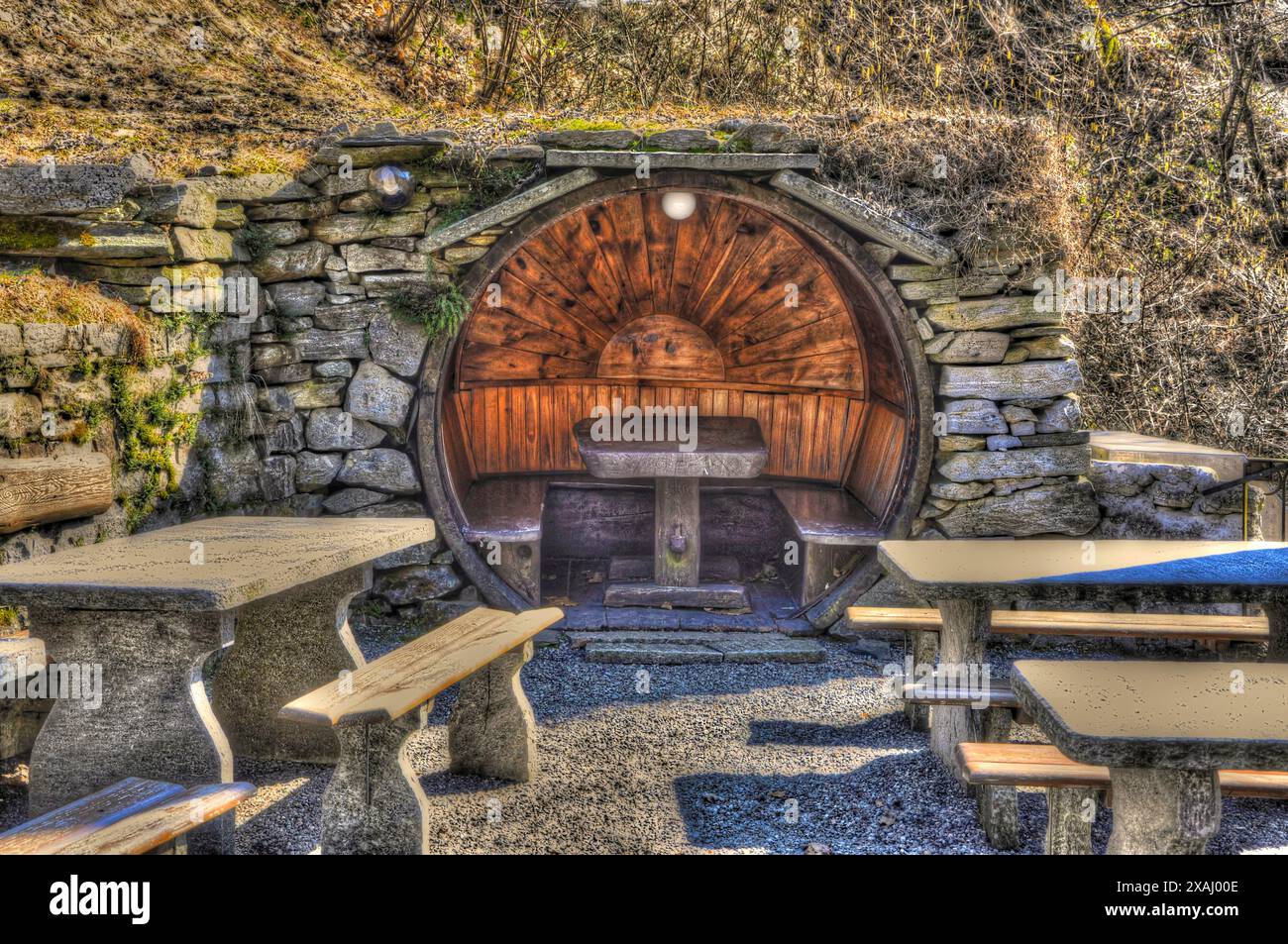 Restaurant rustique avec tables et bancs fabriqués en pierre et bois en forme de cercle dans une journée ensoleillée au Tessin, Suisse Banque D'Images