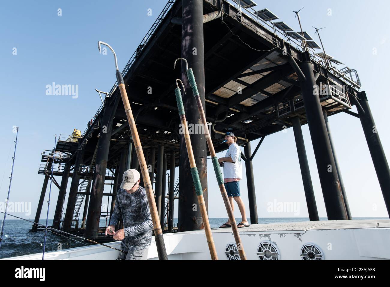 Les pêcheurs pêchent le poisson appât lorsqu'ils sont entourés de plates-formes pétrolières offshore dans le golfe du Mexique près de Venise, en Louisiane. Banque D'Images