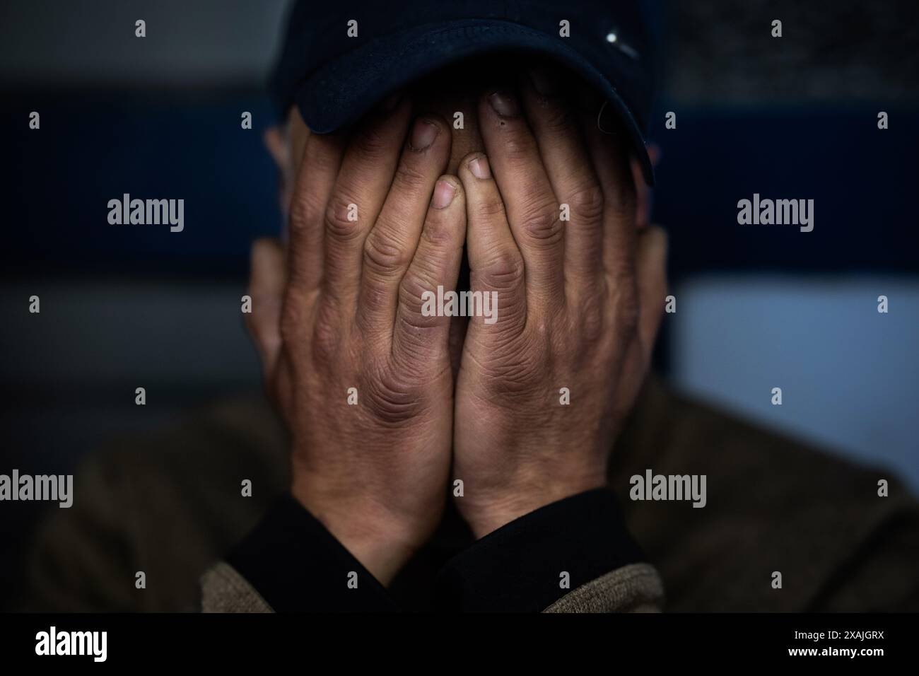 PRODUCTION - 06 mai 2024, Hesse, Francfort-sur-le-main : Amar (nom changé) est assis dans sa maison sûre dans une entrée de bâtiment dans le quartier de la gare de Francfort et tient ses mains devant son visage. L’homme de 50 ans est lui-même toxicomane, mais il a peur des agressions physiques d’autres junkies. (À dpa 'vues intérieures de Zombieland' du 08.06.2024) photo : Boris Roessler/dpa Banque D'Images