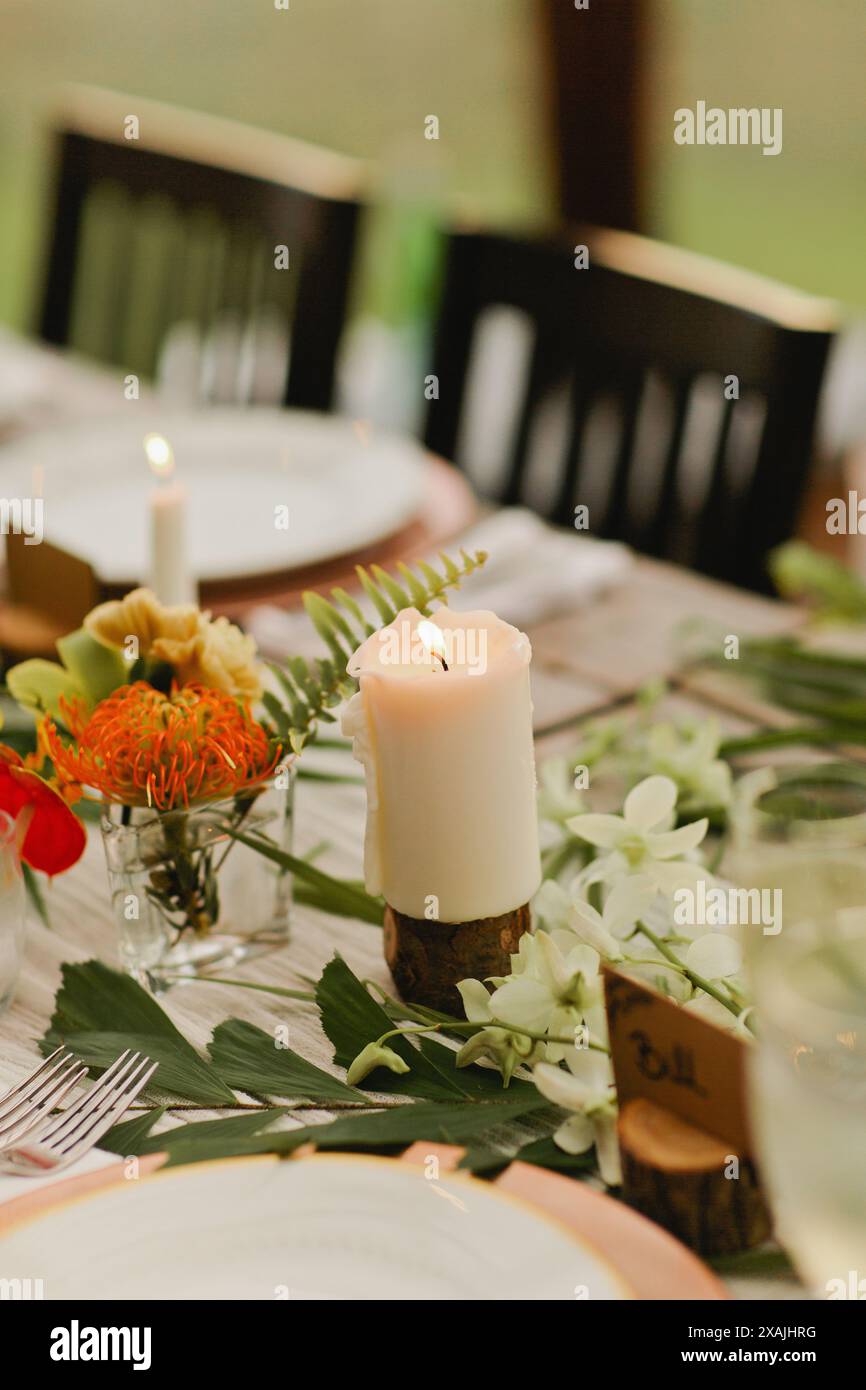 Bougie brûlante blanche avec flamme nue repose sur la table Banque D'Images