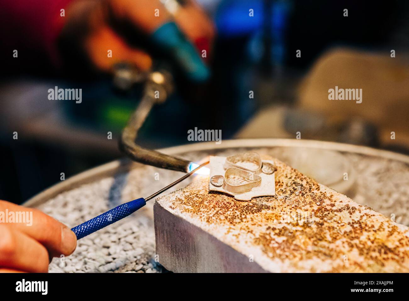 Cose up shot des mains de bijoutiers en utilisant la torche de bijoux pour souder Banque D'Images
