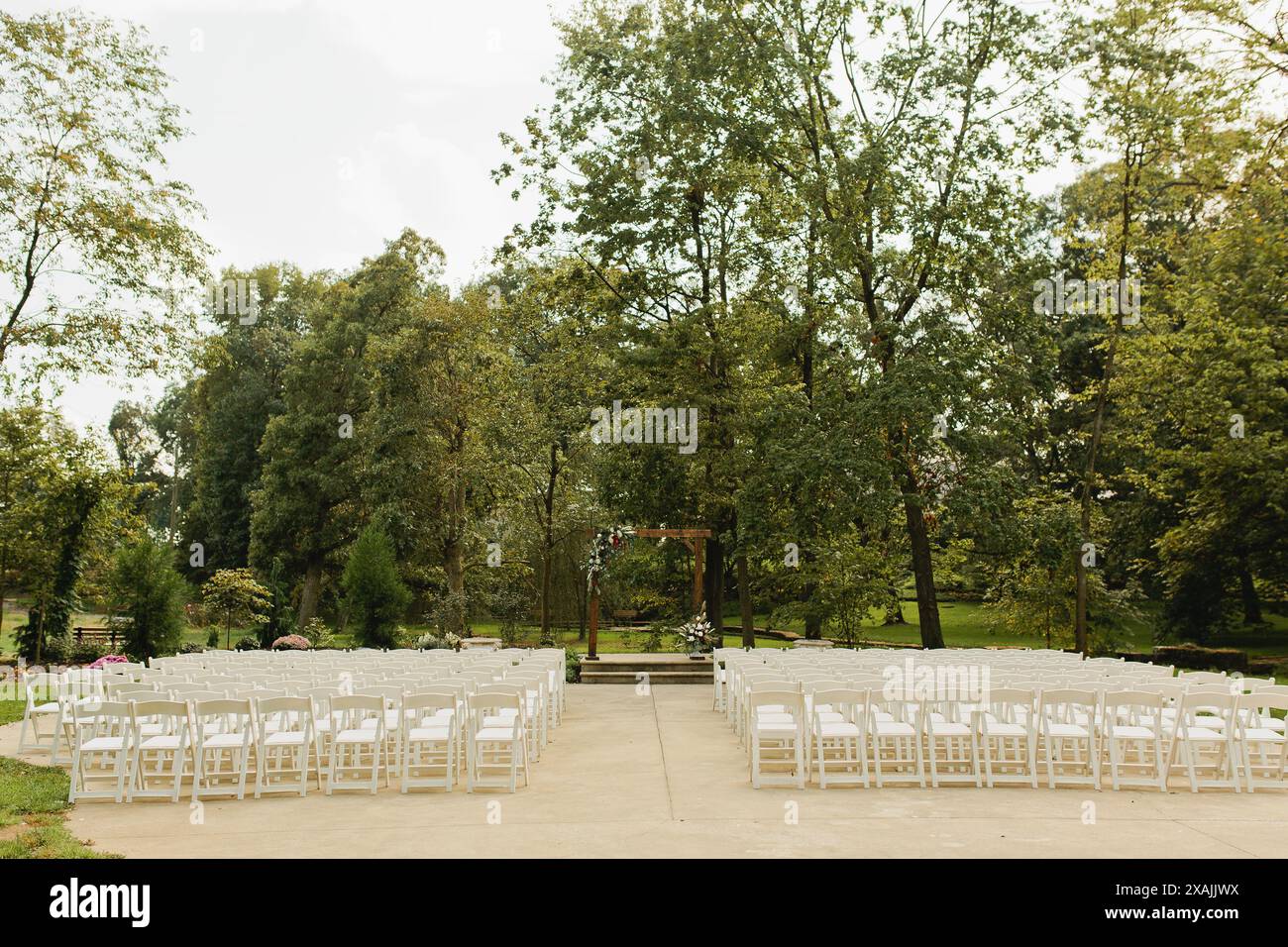 Site de cérémonie de mariage avec chaises blanches et fleurs Banque D'Images