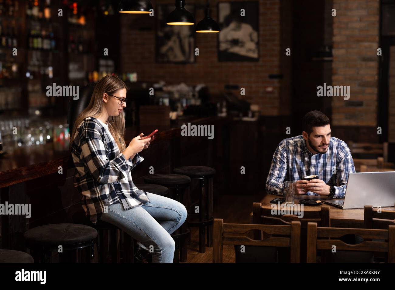 Deux jeunes, mari et femme, propriétaires de pubs, travaillant dans leur cafétéria, nettoyant et calculant avant l'heure d'ouverture. L'homme et la femme travaillent dans le café Banque D'Images