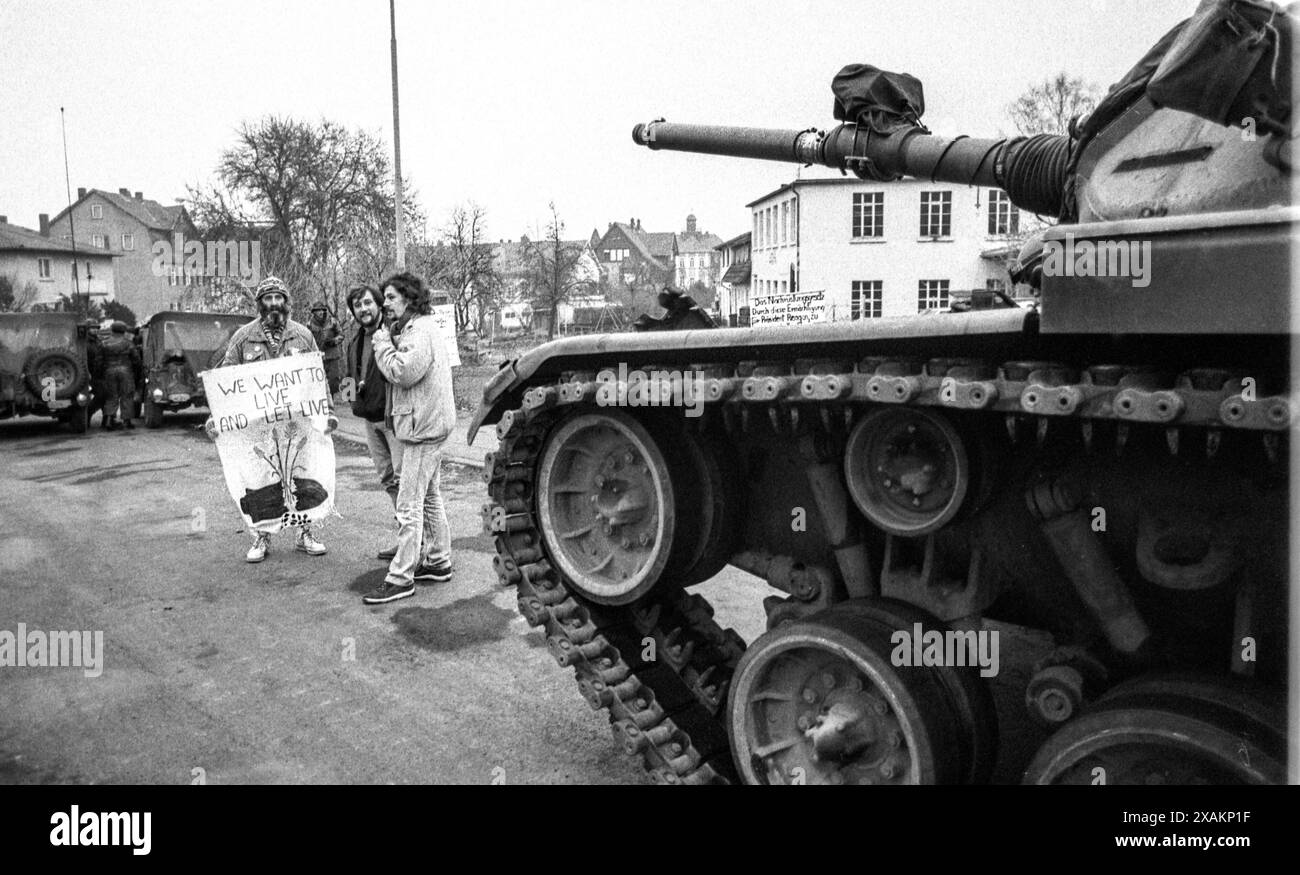 Militants de la paix avec la bannière "nous voulons vivre et laisser vivre" devant la colonne des chars, actions du mouvement de paix contre la manœuvre "Warsteed" en mars 1984 Banque D'Images