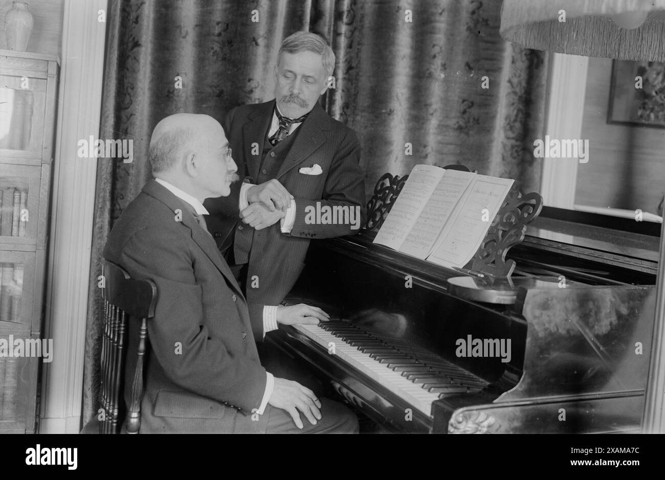 A.E. Johnstone & amp ; Harvey Loomis, entre 1918 et 1920. Montre les compositeurs Arthur Edward Johnstone (1860-1944) et Harvey Worthington Loomis (1865-1930) qui ont collaboré à l'écriture de chansons. Au piano se trouve la partition de l'une de leurs compositions "America's message", qui a été protégée par copyright en 1918. Banque D'Images