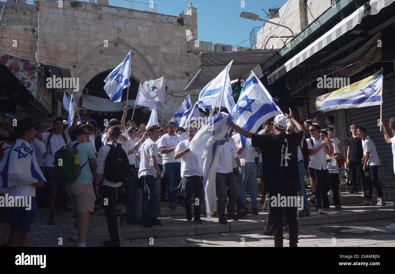 JÉRUSALEM - 5 JUIN : les Israéliens ultra-nationalistes marchent avec des drapeaux israéliens dans la rue Al-Wad dans le quartier musulman lors de la "Marche du drapeau" nationaliste juive pour marquer la "Journée de Jérusalem" dans la vieille ville le 5 juin 2024 à Jérusalem. Israël. La marche annuelle du drapeau de la Journée de Jérusalem attire généralement des milliers d'Israéliens nationalistes qui défilent à travers la ville, y compris le quartier musulman de la vieille ville. Banque D'Images