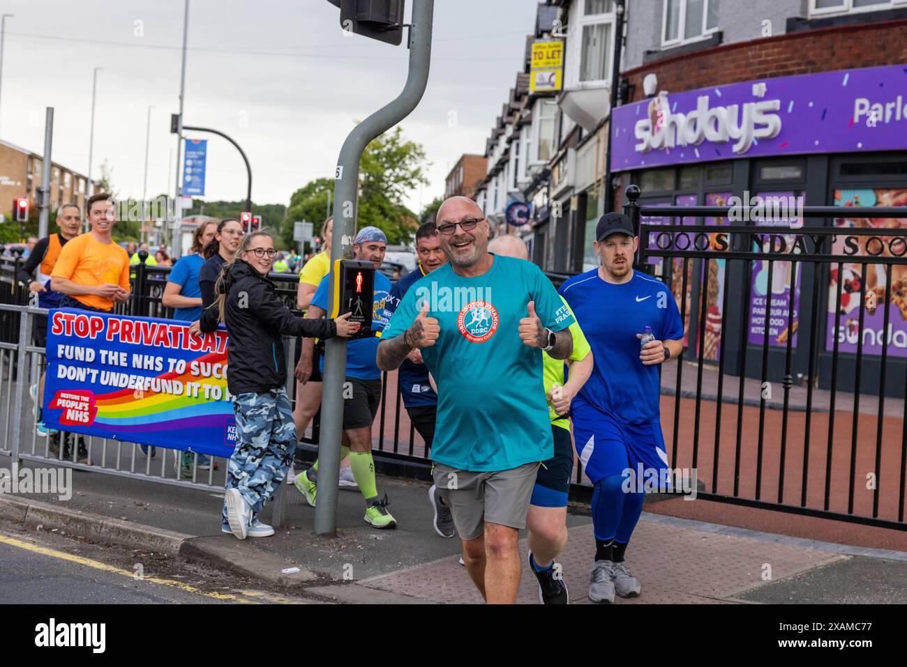 Leeds, Royaume-Uni. 07 JUIN 2024. Les coureurs posent devant la caméra alors qu'ils prennent part à une route de 7 miles, en forme de rhinocéros, à travers les rues de la ville de Moor en l'honneur de la légende Leeds Rhinos numéro 7 Rob Burrow, décédé dimanche à l'âge de 41 ans après une bataille de plus de 4 ans contre la maladie du motoneurone (MND). Crédit Milo Chandler/Alamy Live News Banque D'Images