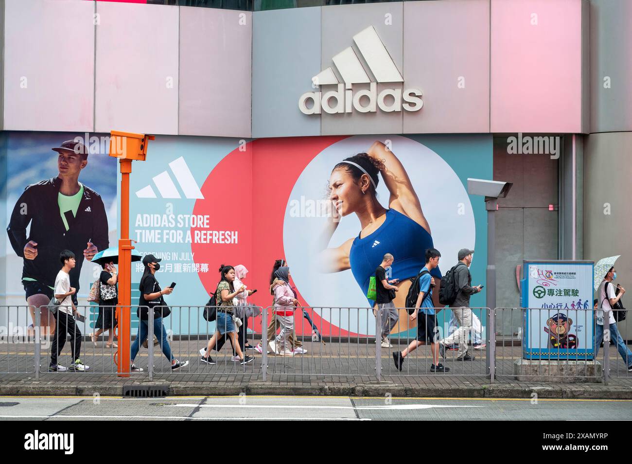 Des piétons marchent devant le magasin Adidas de la marque multinationale allemande de vêtements de sport à Hong Kong. Banque D'Images