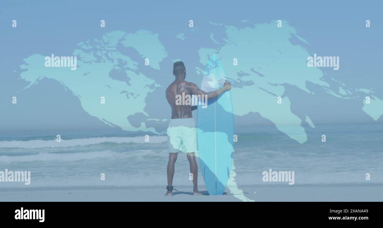 Image de la carte du monde sur la vue arrière de l'homme afro-américain tenant une planche de surf sur la plage Banque D'Images