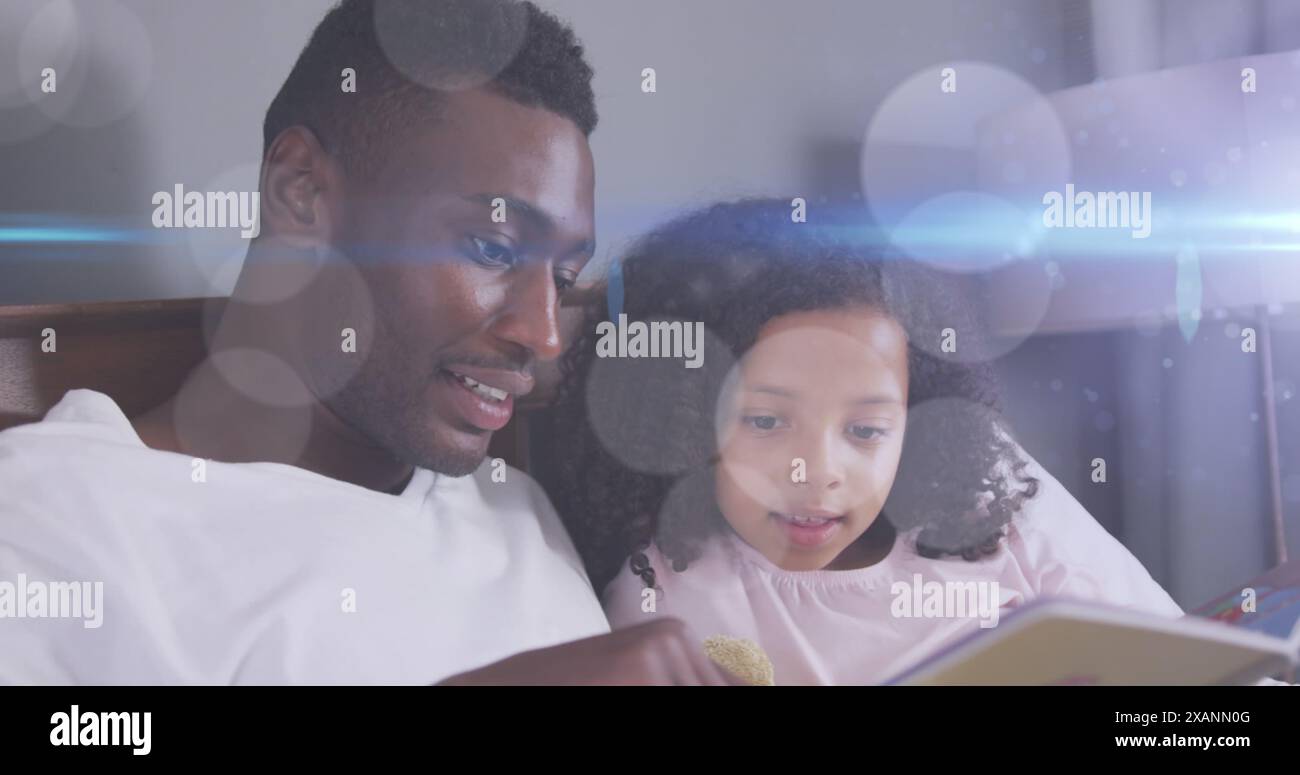 Image de taches lumineuses sur heureux père afro-américain lisant livre avec fille Banque D'Images