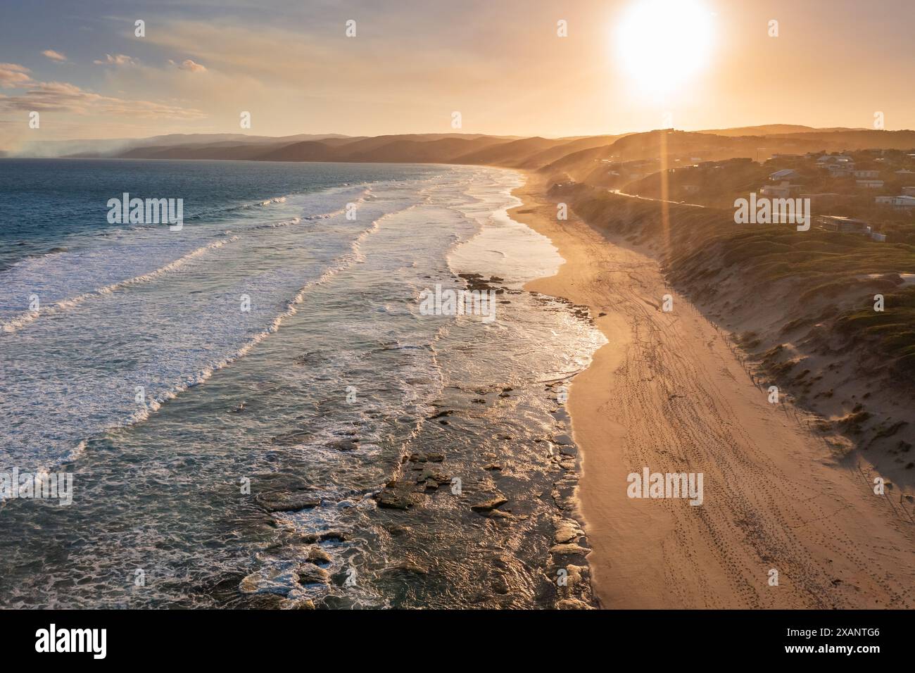 Vue aérienne des vagues de l'océan sur une côte sablonneuse au coucher du soleil à Aireys Inlet sur la Great Ocean Road à Victoria, Australie Banque D'Images