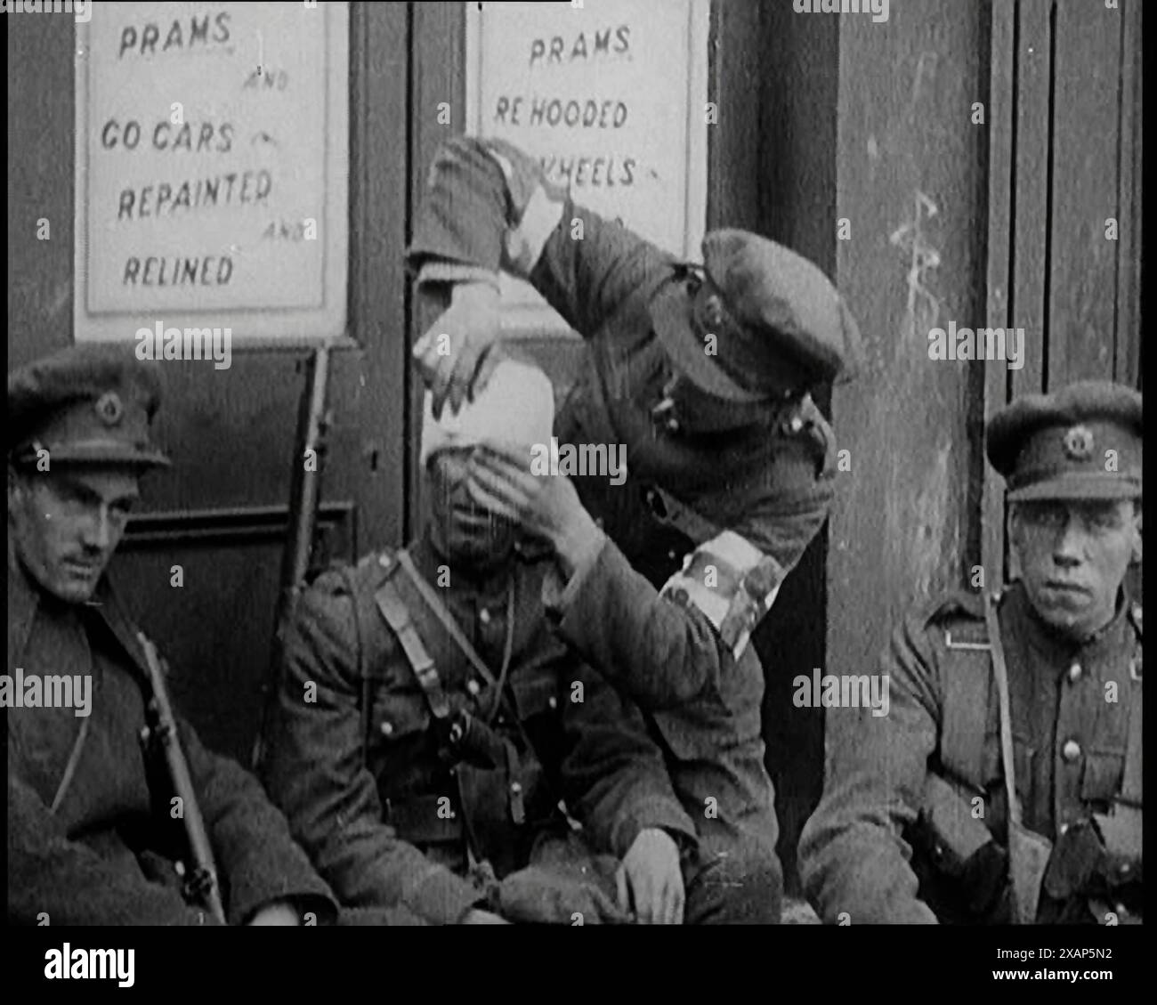 Soldats irlandais assis dans la rue et soignant leurs blessures lors de combats à Dublin, 1922. De "Time to Remember - Sitting Still and Going Slowly", 1922 (bobine 4) ; un examen des événements de 1922, y compris les troubles irlandais, la guerre entre la Grèce et la Turquie et les développements dans l'aviation et la radio. Banque D'Images