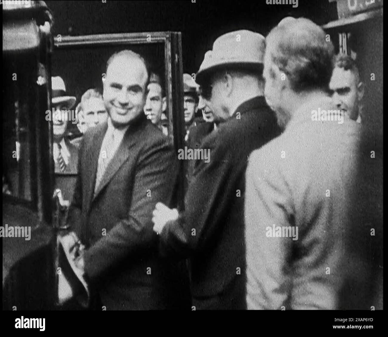 Alphonse Gabriel Capone alias 'Al Capone' entrant dans une voiture surveillée par une petite foule, 1930s. "Ce fut la plus grande surprise du siècle quand Gentle Al a été mis de côté pendant onze ans pour ne pas avoir payé son impôt sur le revenu". De "Time to Remember - The Tough Guys", années 1930 (Reel 1) ; un film documentaire, principalement sur la vie dans la dépression et les gangsters américains. Banque D'Images Alphonse Gabriel Capone alias 'Al Capone' entrant dans une voiture surveillée par une petite foule, 1930s. "Ce fut la plus grande surprise du siècle quand Gentle Al a été mis de côté pendant onze ans pour ne pas avoir payé son impôt sur le revenu". De "Time to Remember - The Tough Guys", années 1930 (Reel 1) ; un film documentaire, principalement sur la vie dans la dépression et les gangsters américains. Banque D'Images