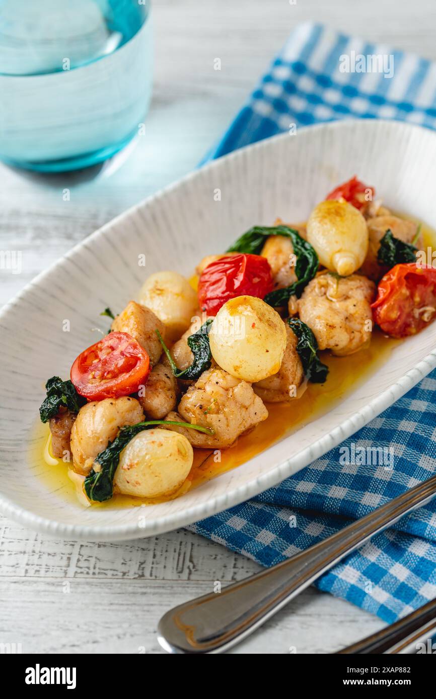 Apéritif avec des crevettes, des oignons et des tomates sur une assiette en porcelaine blanche Banque D'Images
