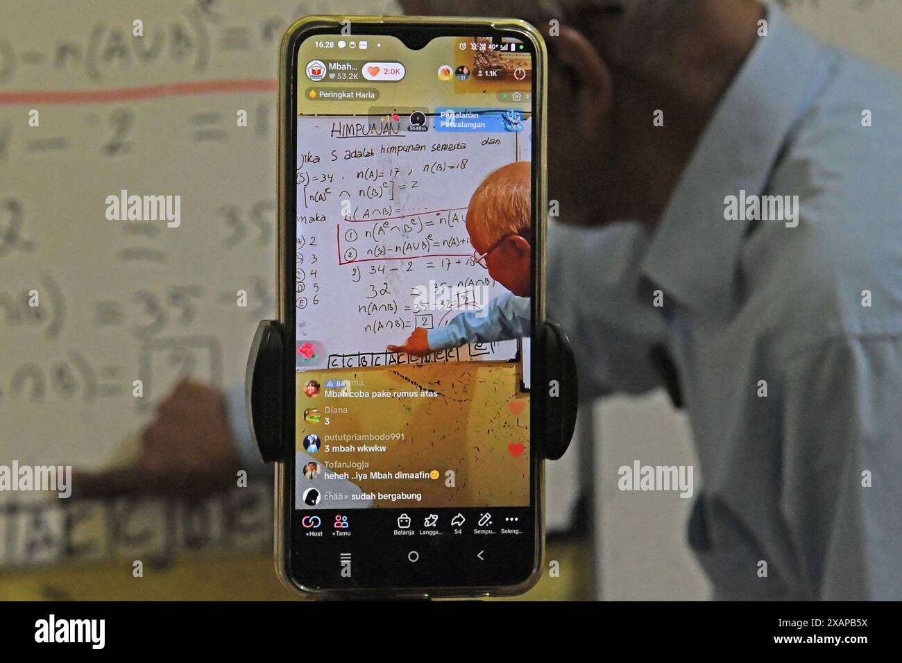 7 juin 2024, Purworejo, Java central, Purworejo : MELAN Achmad (78) un professeur de mathématiques à la retraite enseigne et apprend toujours en utilisant les médias sociaux avec l'aide de son fils comme vidéaste via téléphone portable à son domicile de Purworejo, Java central. MELAN Achmad, communément appelé Mbah Matematika, est à la retraite depuis 2003, mais son enthousiasme pour le partage des connaissances n'a jamais été éteint en utilisant les médias sociaux TikTok appelés ''˜@binaprestasiwa' pour atteindre les étudiants en partageant des matériaux mathématiques pour le primaire, le collège et le lycée, et en discutant des questions de test d'entrée à l'université. MBA Banque D'Images