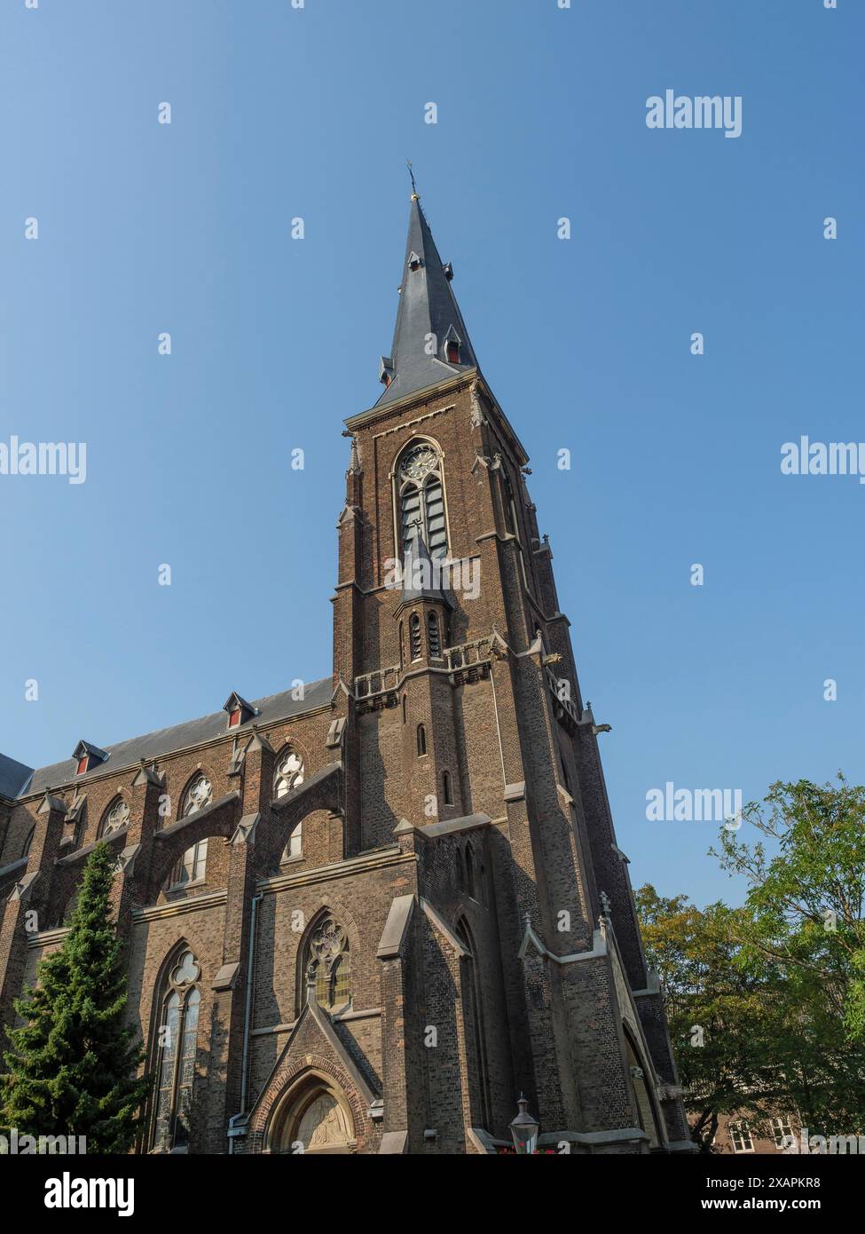 Grande église gothique avec haute tour et fenêtres en arc pointu en brique rouge sous un ciel clair, Maastricht, Limbourg, pays-Bas Banque D'Images