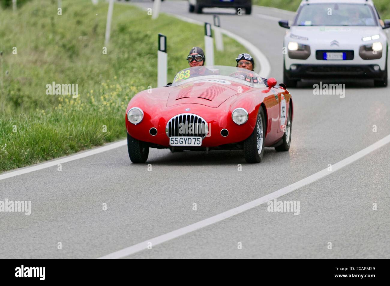 Une voiture de course vintage rouge conduit sur une route de campagne sinueuse, entourée par la nature verte, voiture classique, course automobile, mille Miglia, 1000 Miglia, 2015 Banque D'Images