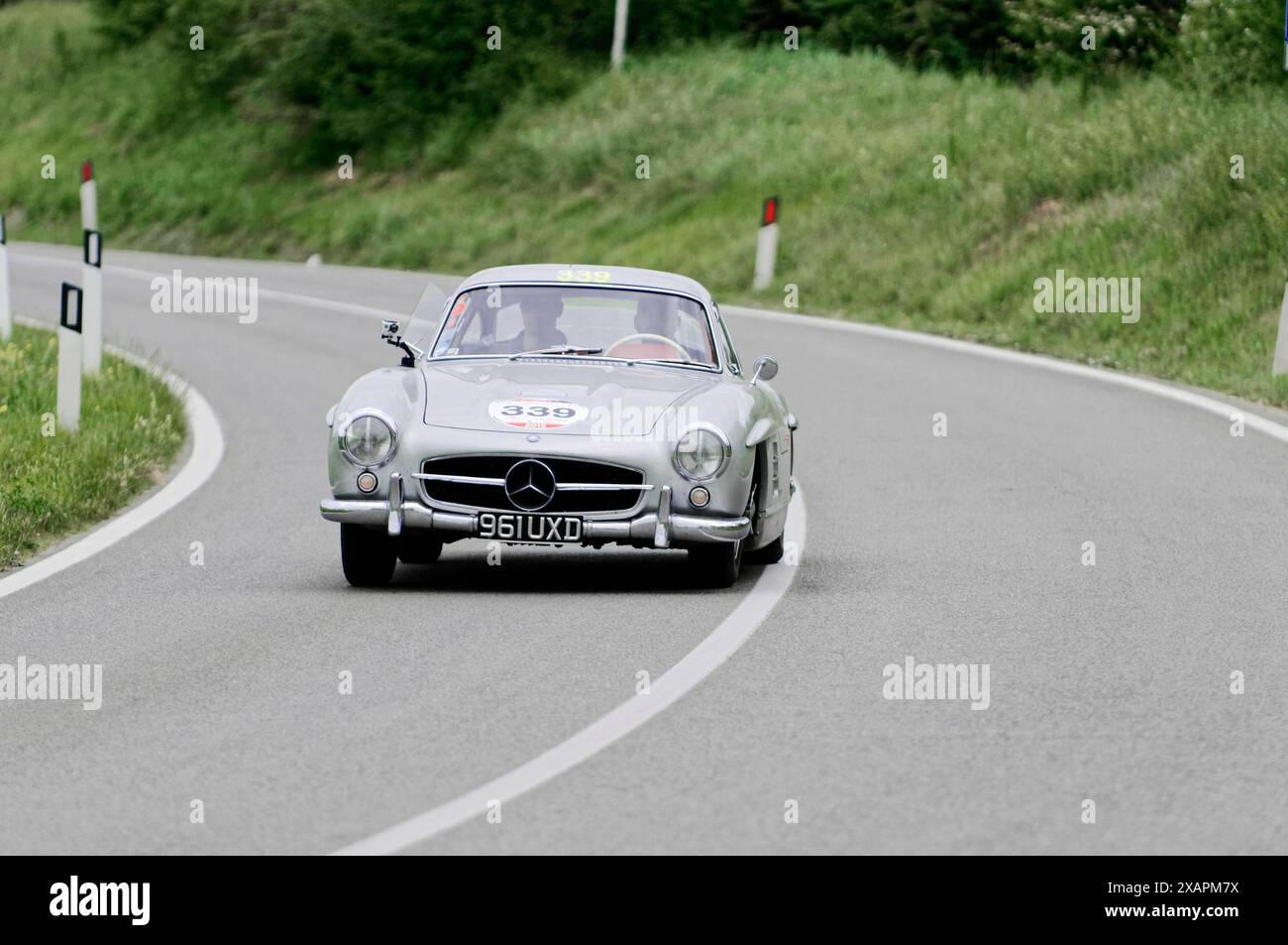 Une Mercedes-Benz classique argentée roule sur une route de campagne sinueuse lors d'une course de voitures classiques, voiture classique, course de voitures, mille Miglia, 1000 Miglia, Toscane Banque D'Images