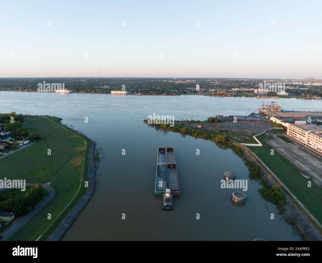 Une vue aérienne capture une barge quittant le canal industriel dans le 9th Ward historique de la Nouvelle-Orléans, entrant dans le fleuve Mississippi à l'aube. Banque D'Images