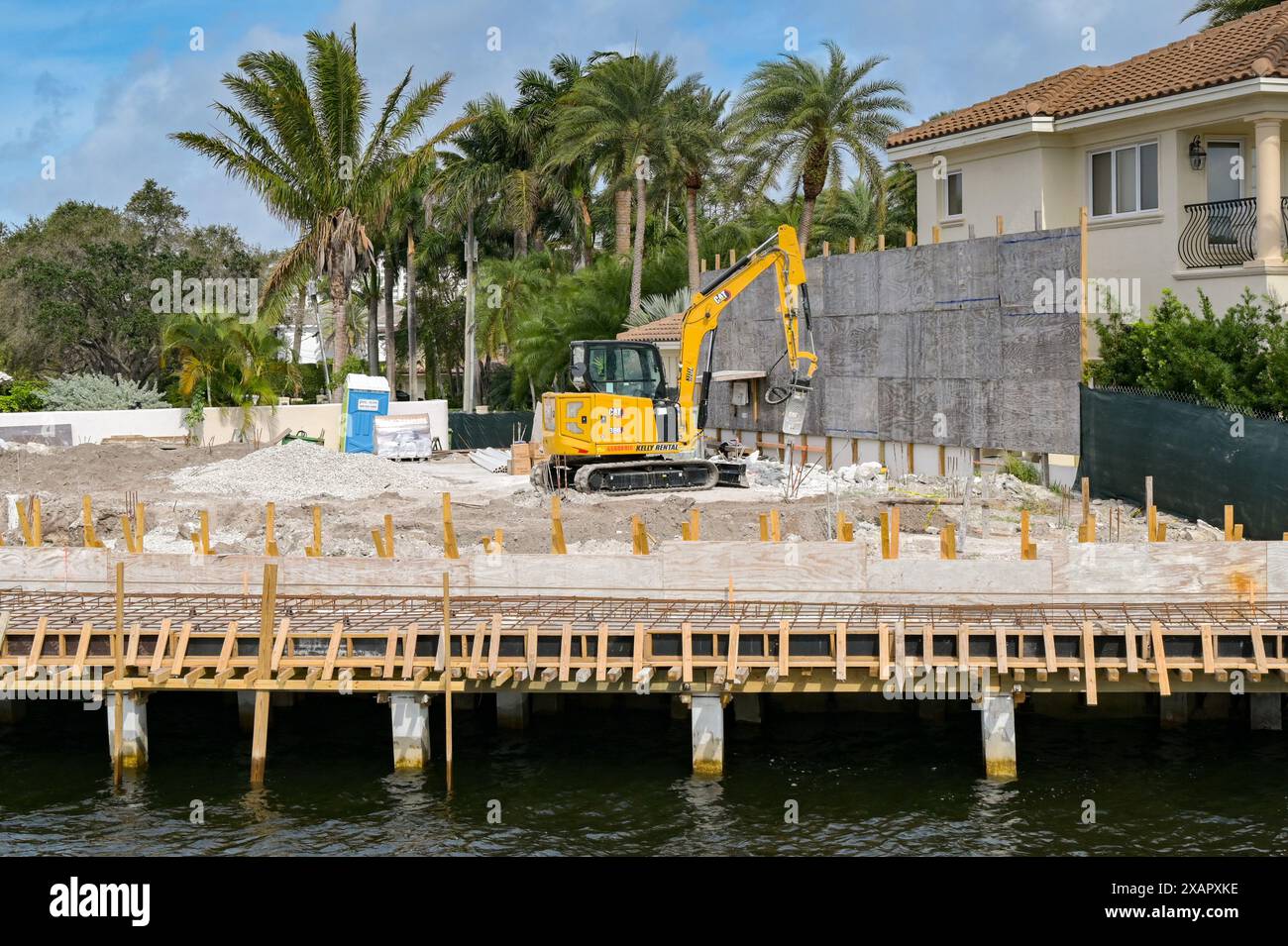Fort Lauderdale, Floride, États-Unis - 2 décembre 2023 : petite pelle travaillant sur les fondations d'une nouvelle maison de luxe sur un chantier de construction Banque D'Images Fort Lauderdale, Floride, États-Unis - 2 décembre 2023 : petite pelle travaillant sur les fondations d'une nouvelle maison de luxe sur un chantier de construction Banque D'Images