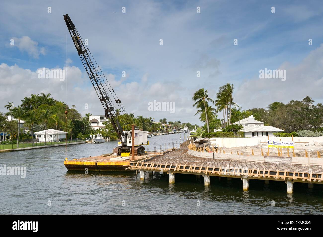 Fort Lauderdale, Floride, États-Unis - 2 décembre 2023 : grue sur une barge amarrée le long du chantier de construction des fondations d'une nouvelle maison de luxe Banque D'Images Fort Lauderdale, Floride, États-Unis - 2 décembre 2023 : grue sur une barge amarrée le long du chantier de construction des fondations d'une nouvelle maison de luxe Banque D'Images