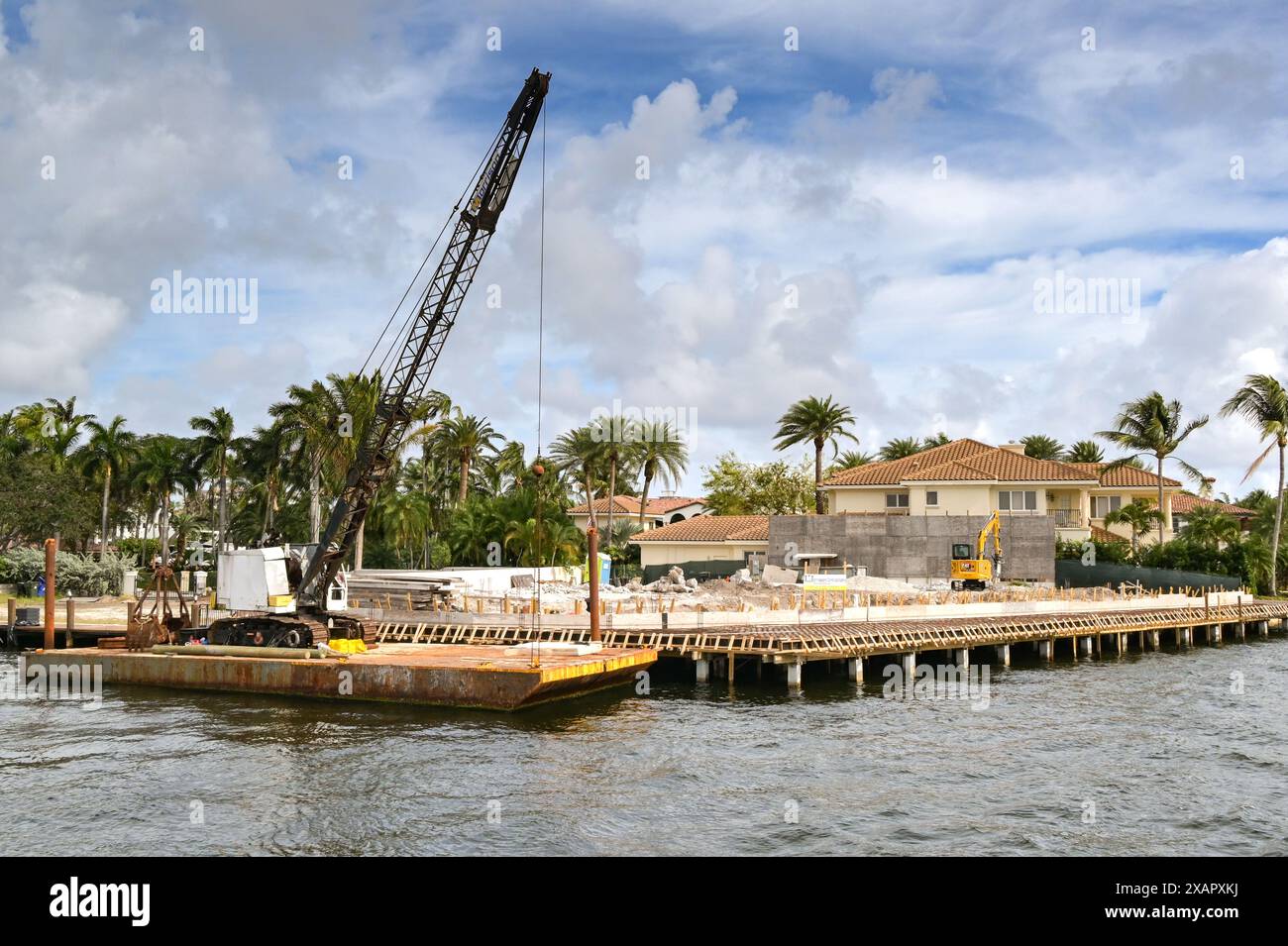 Fort Lauderdale, Floride, États-Unis - 2 décembre 2023 : grue sur une barge amarrée le long du chantier de construction des fondations d'une nouvelle maison de luxe Banque D'Images Fort Lauderdale, Floride, États-Unis - 2 décembre 2023 : grue sur une barge amarrée le long du chantier de construction des fondations d'une nouvelle maison de luxe Banque D'Images
