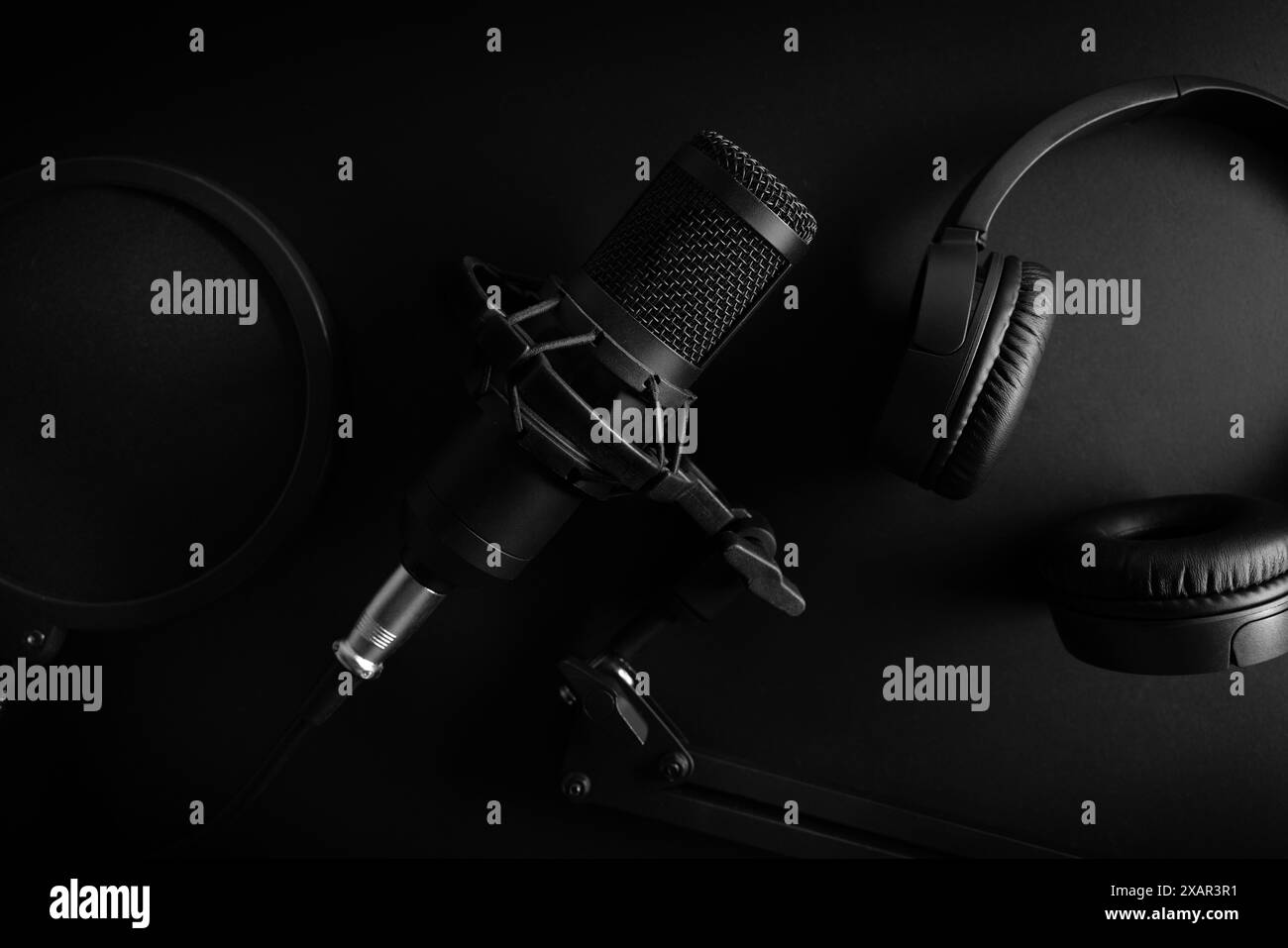 microphone studio et écouteurs sur fond noir. matériel professionnel d'enregistrement sonore. vue de dessus Banque D'Images