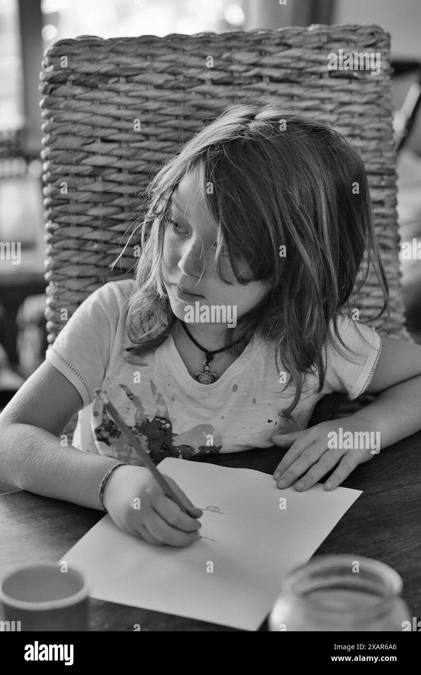 Italie, Sicile, Marina di Ragusa (Province de Ragusa) ; enfant mâle de 8 ans dessinant sur la table d'un salon dans un appartement privé Banque D'Images