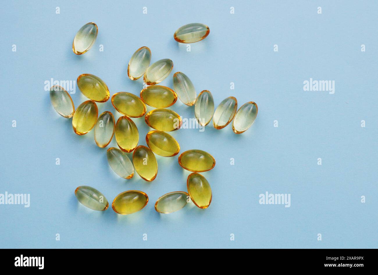 Nutrition et remplissage de vitamines dans la capsule de gélatine molle colorée. Capsules jaunes transparentes d'huile de poisson. Banque D'Images