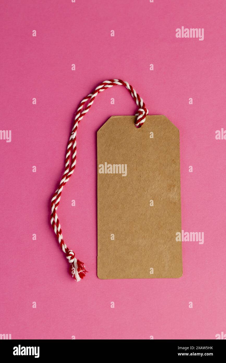 ancienne étiquette de vêtements en carton fabriquée à partir de vieux papiers recyclés étiquette d'article écologique sur fond rose Banque D'Images