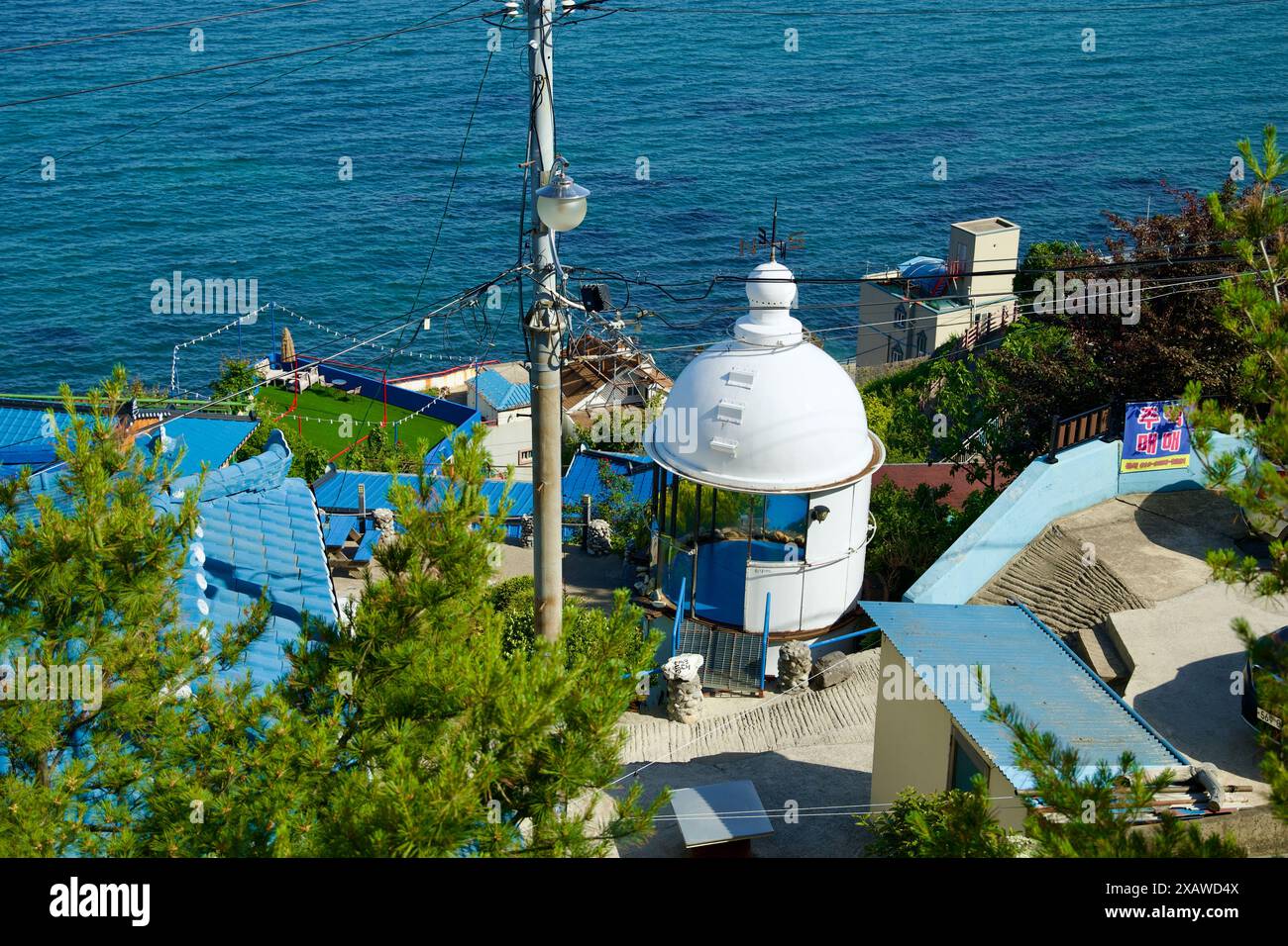 Donghae City, Corée du Sud - 18 mai 2024 : une vue pittoresque de Nongoldam Street, avec des toits bleus vibrants et une vieille structure de phare, w Banque D'Images