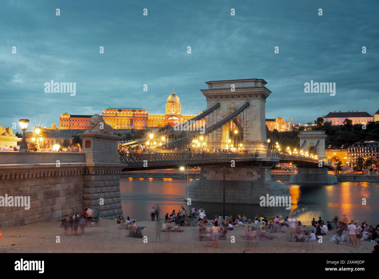 Chain Bridge et vue sur le château royal la nuit, les gens sur le rivage Banque D'Images