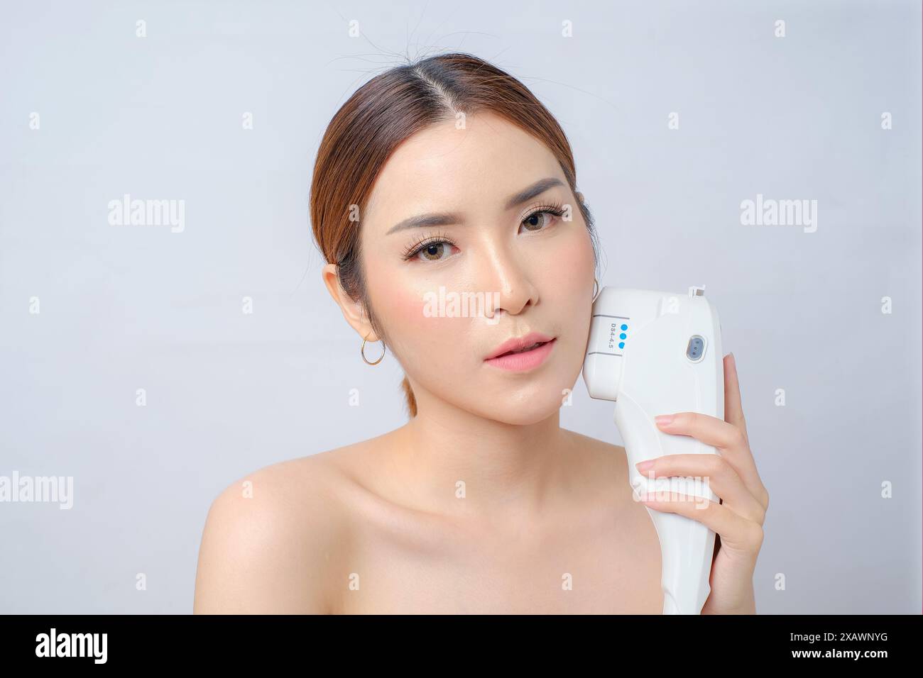 Belle jeune femme asiatique subissant un traitement laser HIFU à la clinique de beauté Banque D'Images