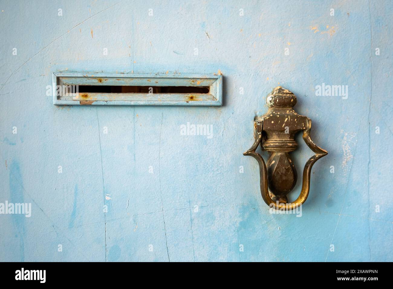 Détail d'une porte métallique marocaine typique. Vous pouvez voir un frappeur en bronze et une fente pour déposer le courrier. La porte est bleue et se trouve à Rabat, Maroc Banque D'Images