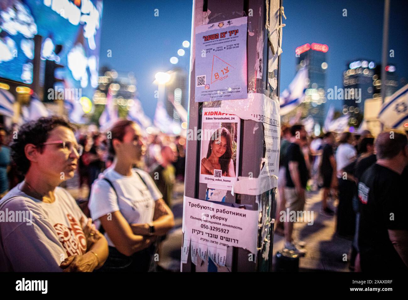 Les manifestants se tiennent à côté d'une petite image d'Eden Yerushalmi qui est retenu en otage par le Hamas à Gaza lors d'une manifestation à tel Aviv, samedi, 8 juin 2024.des milliers de manifestants se sont rassemblés dans des dizaines de lieux à travers Israël samedi soir pour appeler à un accord d'otages et à de nouvelles élections quelques heures seulement après la nouvelle du sauvetage des quatre otages C Noa Argamani, Almog Meir Jan, Andrey Kozlov et Shlomi Ziv C. Photo par Eyal Warshavsky. Banque D'Images
