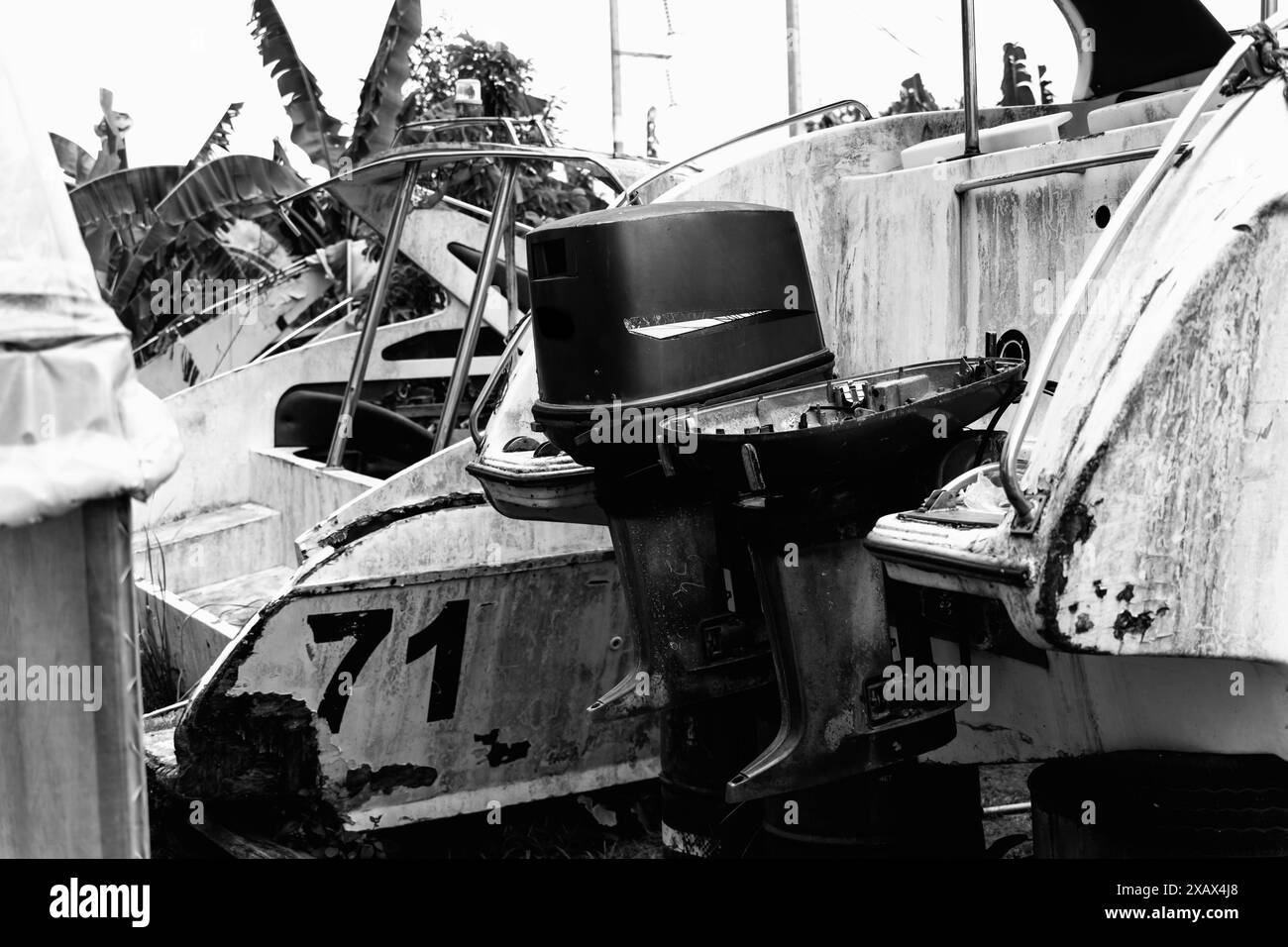 Bateaux à moteur vieux et rouillés sur une décharge entourée de forêt tropicale Banque D'Images