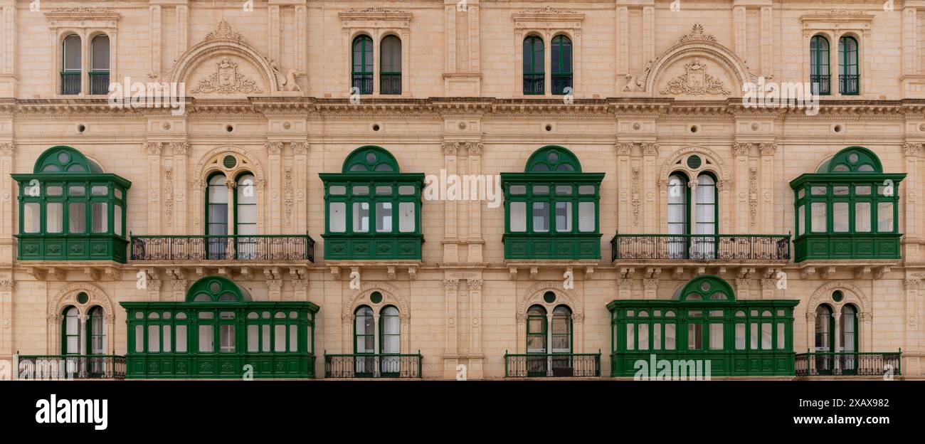 Mur de maison typique à Malte. Briques jaunes calcaires et balcons colorés. Par exemple grreen Banque D'Images