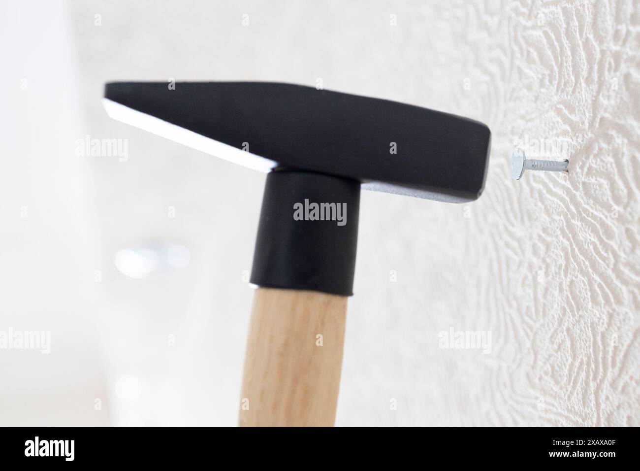 marteau marteaux clou dans le mur blanc à la maison gros plan Banque D'Images