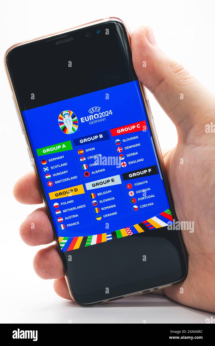 La phase de groupes du Championnat d'Europe de football 2024 sur l'écran d'un téléphone tenu par un homme Banque D'Images