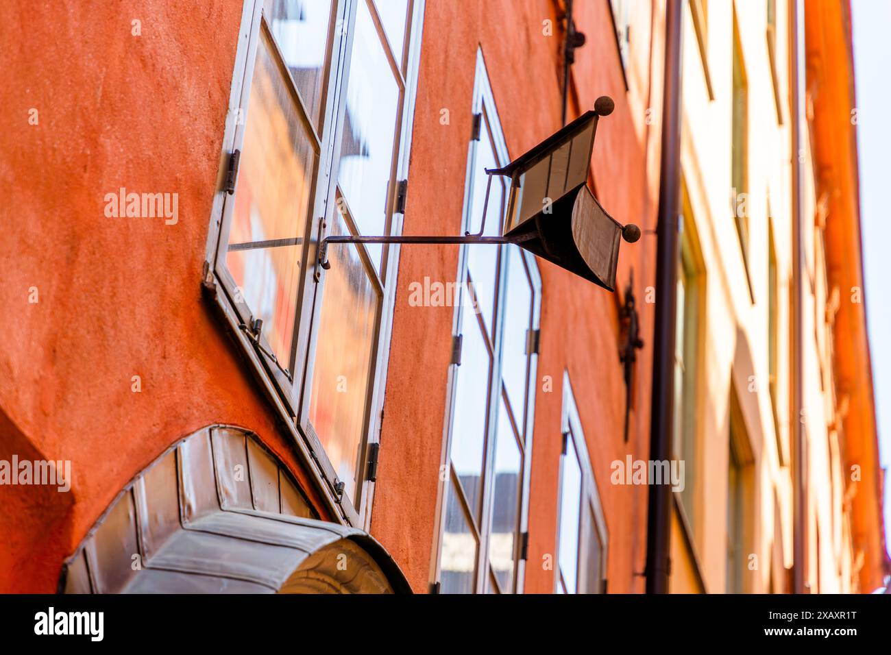 Un miroir à potins du XVIIIe siècle est accroché à une façade de maison dans la vieille ville de Stockholm. À l'époque, les femmes n'étaient pas autorisées à sortir dans la rue sans être accompagnées d'un homme. Le miroir leur permettait de parler aux voisins dans la ruelle depuis l'intérieur, sans quitter la maison. Gamla Stan, Stockholm, Comté de Stockholm, Suède. Banque D'Images