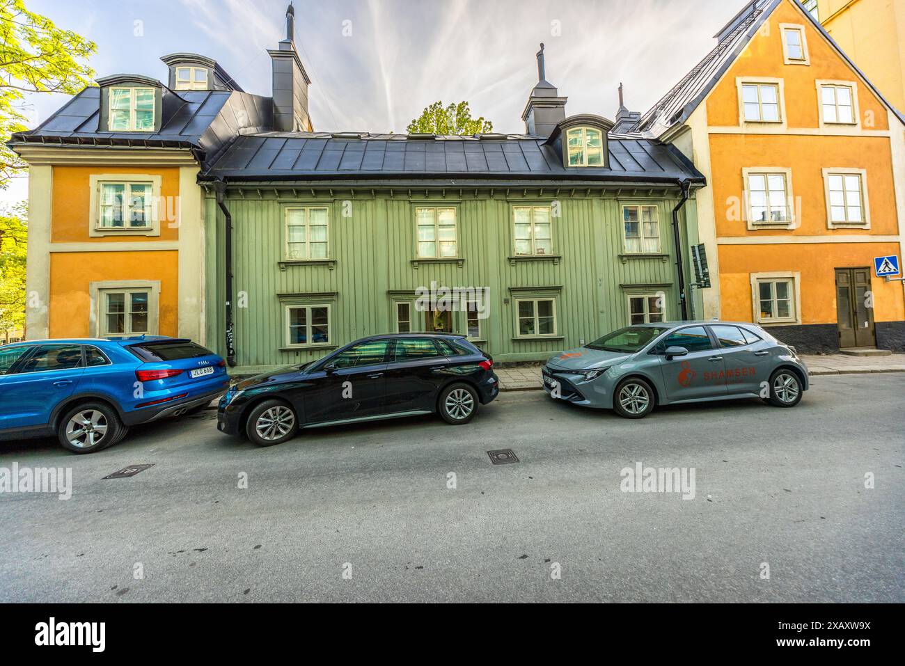 Maison verte en bois dans le quartier de Södermalm. Une des rares maisons en bois construites dans le style traditionnel ancien au 17ème siècle. La plupart des maisons ont brûlé ou ont été démolies. Vue sur la ville dans le quartier de Södermalm avec l'église luthérienne (Katarina Kyrka), Stockholm, Suède Banque D'Images