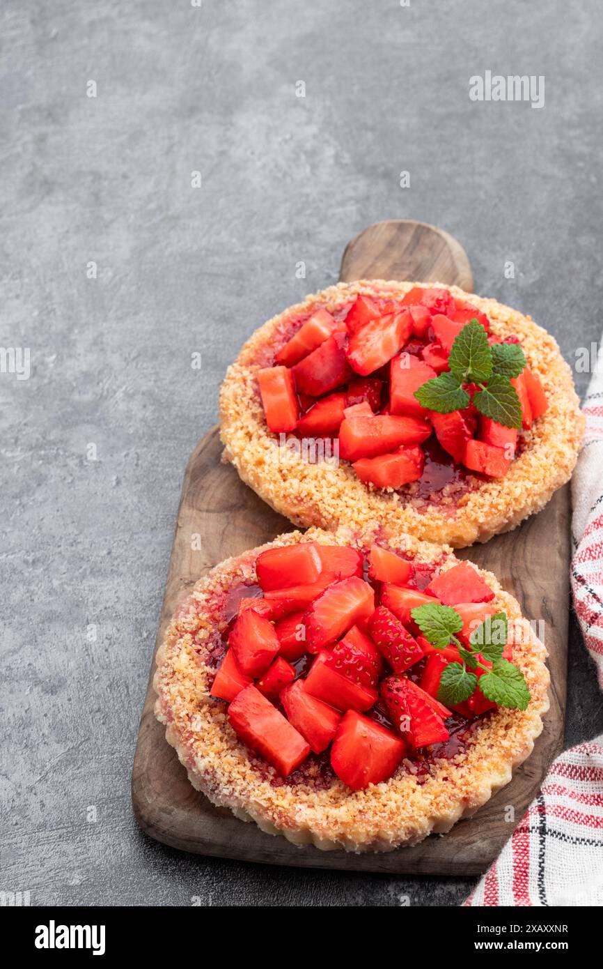 Délicieuses mini tartelettes à la fraise sur fond gris Banque D'Images