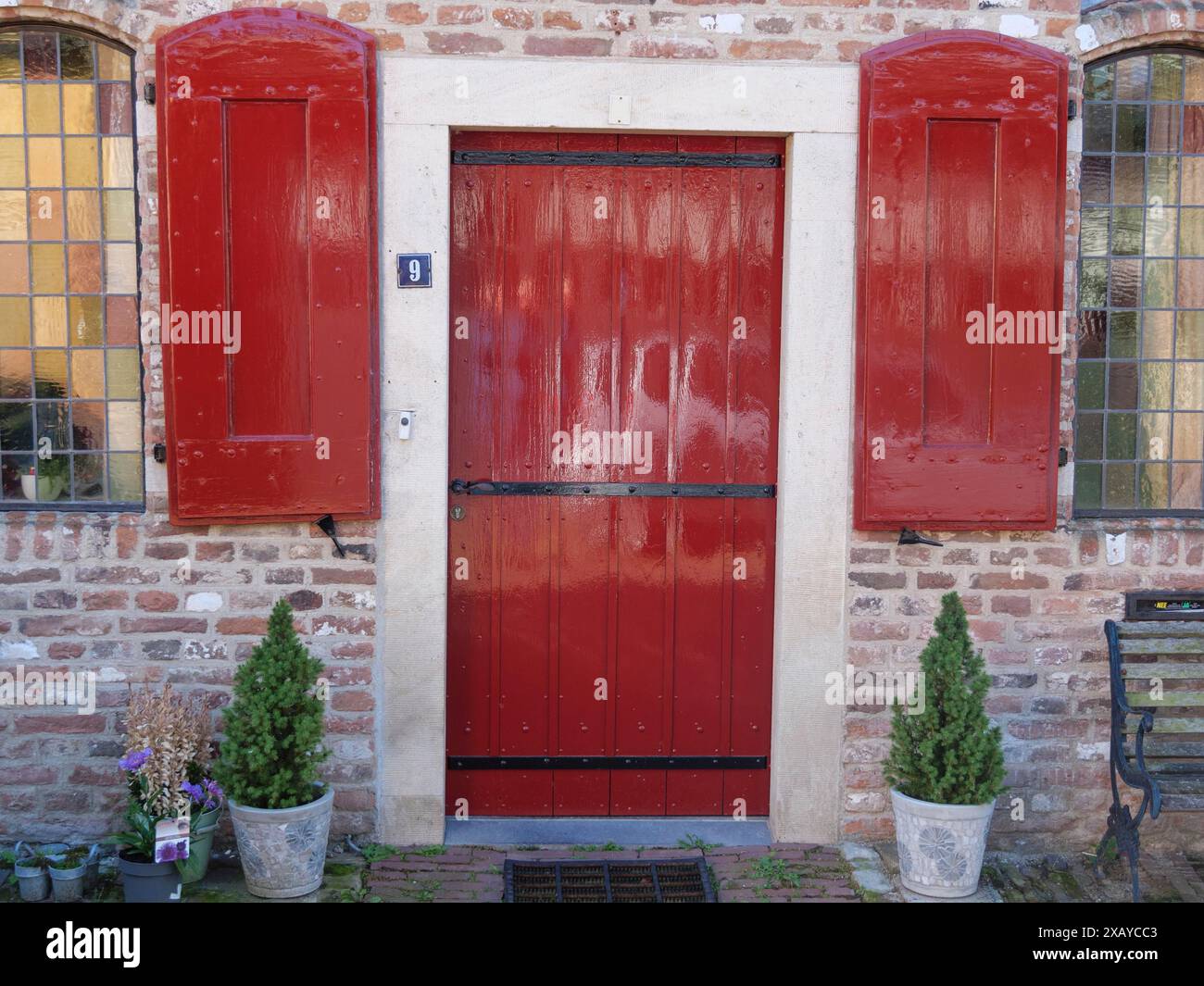 Une porte rouge avec des volets assortis et deux plantes en pot devant elle, Doesburg, pays-Bas Banque D'Images